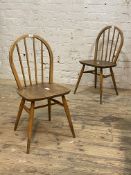 Ercol, A pair of elm and beech dining chairs, hoop and spindle back over saddle seat, raised on