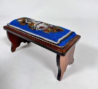 An Edwardian rosewood travelling footrest with beadwork panelled top, with stylised roses and