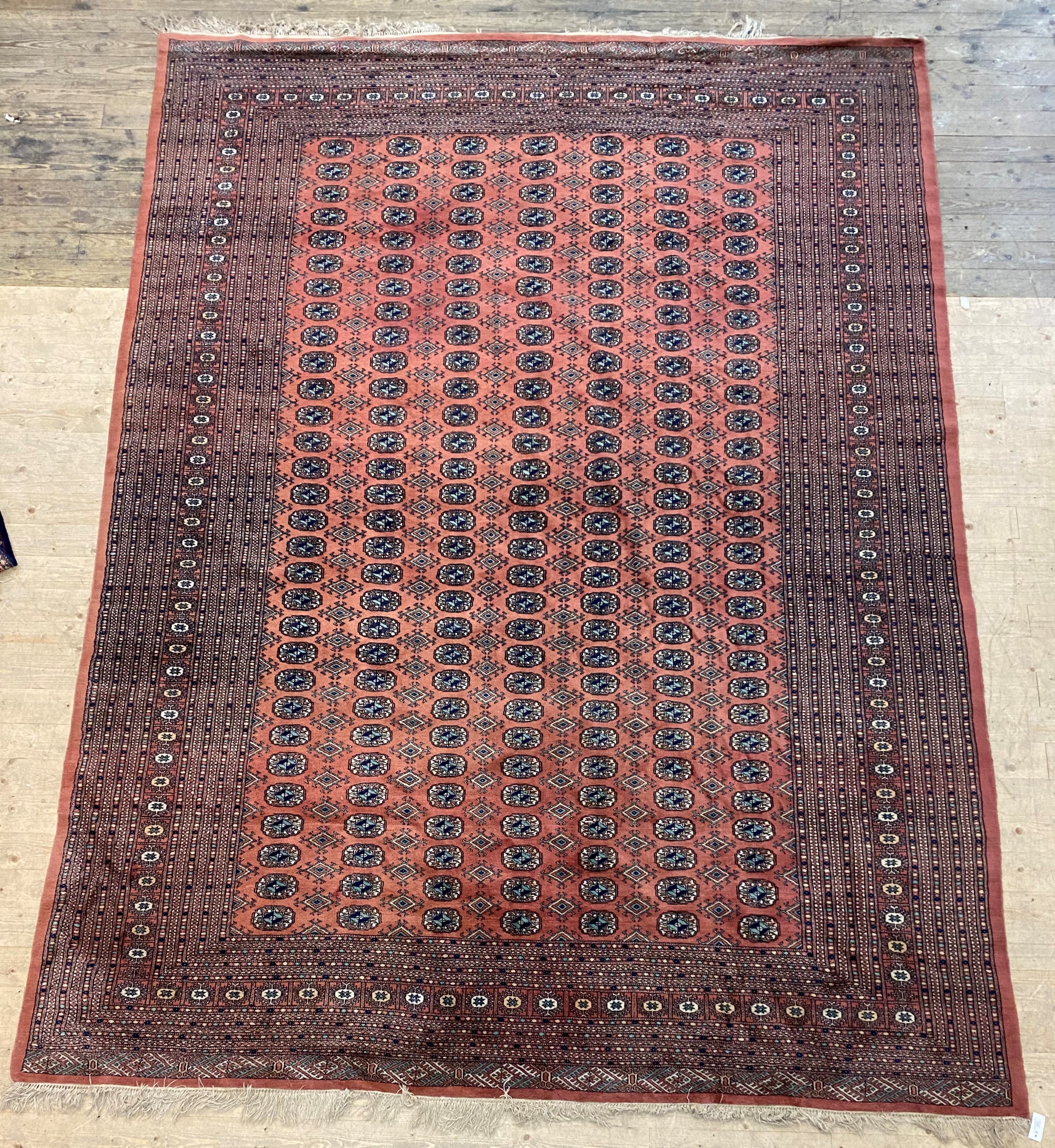 An Afghan bokhara carpet, the red field with multiple rows of guls within a guarded border 379cm x - Image 2 of 2