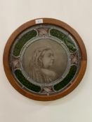 A late 19th century stained and leaded glass roundel, the central panel depicting Queen Victoria,