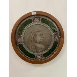 A late 19th century stained and leaded glass roundel, the central panel depicting Queen Victoria,