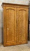 A Victorian bleached satinwood wardrobe, two arched panelled doors enclosing interior fitted for