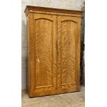 A Victorian bleached satinwood wardrobe, two arched panelled doors enclosing interior fitted for