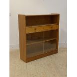 Parker Knoll, a mid century teak bookcase, with open shelf over two drawers and two sliding doors