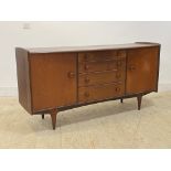 A mid century teak sideboard, circa 1960's, the bowed top over four graduated drawers and two