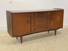 A mid century teak sideboard, circa 1960's, the bowed top over four graduated drawers and two