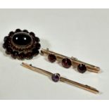 A 9ct gold knife edge bar brooch set three circular graduated garnets, the centre stone approx .5ct,