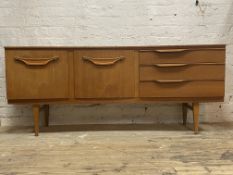 Beautility, a mid century teak sideboard, the concave front fitted with cupboard, fall front