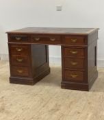 An Edwardian mahogany twin pedestal desk, the top inset with skivered writing surface over three
