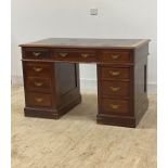 An Edwardian mahogany twin pedestal desk, the top inset with skivered writing surface over three