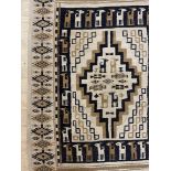A North African flatweave rug of Kilim type, with geometric and stylised animal decoration, 250cm
