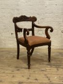 A William IV mahogany elbow chair, with scrolled rail back over drop in seat pad with concave seat
