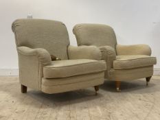 A pair of traditional armchairs, upholstered in gold chenille type fabric, raised on turned front