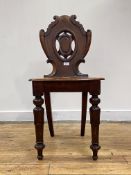 A Victorian mahogany hall chair, the back of scrolled shaped form centred by a vacant cartouche,