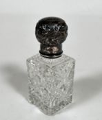 An Edwardian silver mounted crystal slice cut perfume bottle with lift up top enclosing faceted