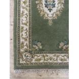 An Indian washed wool rug, the green ground with ivory medallion and bordered 195cm x 97cm