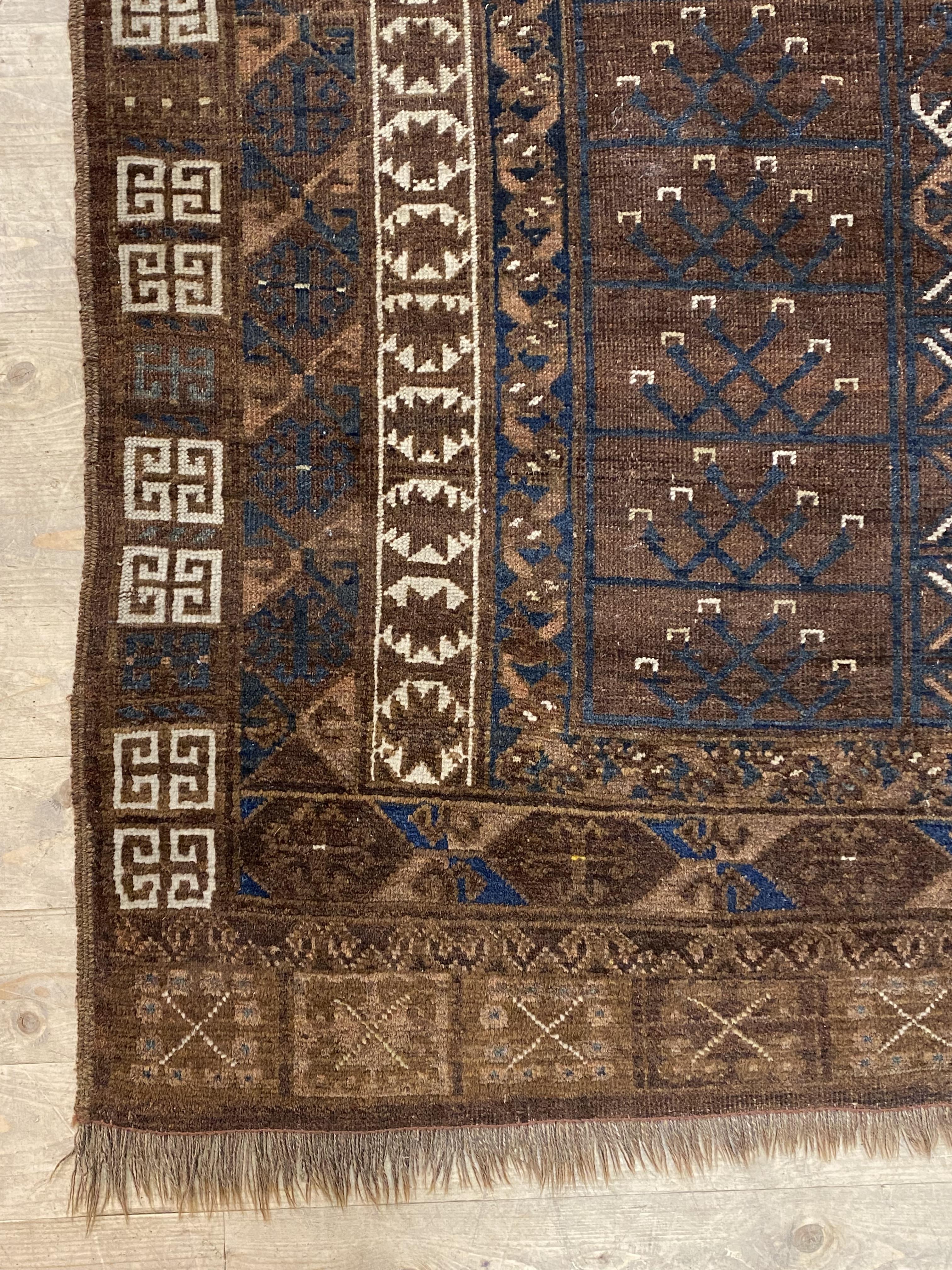 An Antique tribal Turkoman rug, of all over geometric design in browns, reds, blues and ivory