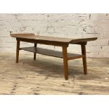 A mid century teak and ply wood coffee table, the dished rectangular top raised on splayed