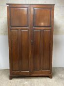 An Edwardian stained mahogany school cupboard or wardrobe, the interior fitted for hanging, with