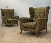 A pair of 1940's wingback easy chairs, in machine embroidered upolstery worked in a floral design,