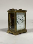 A brass carriage timepiece, mid 20th century, the case with swing handle over oval view window to