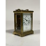 A brass carriage timepiece, mid 20th century, the case with swing handle over oval view window to