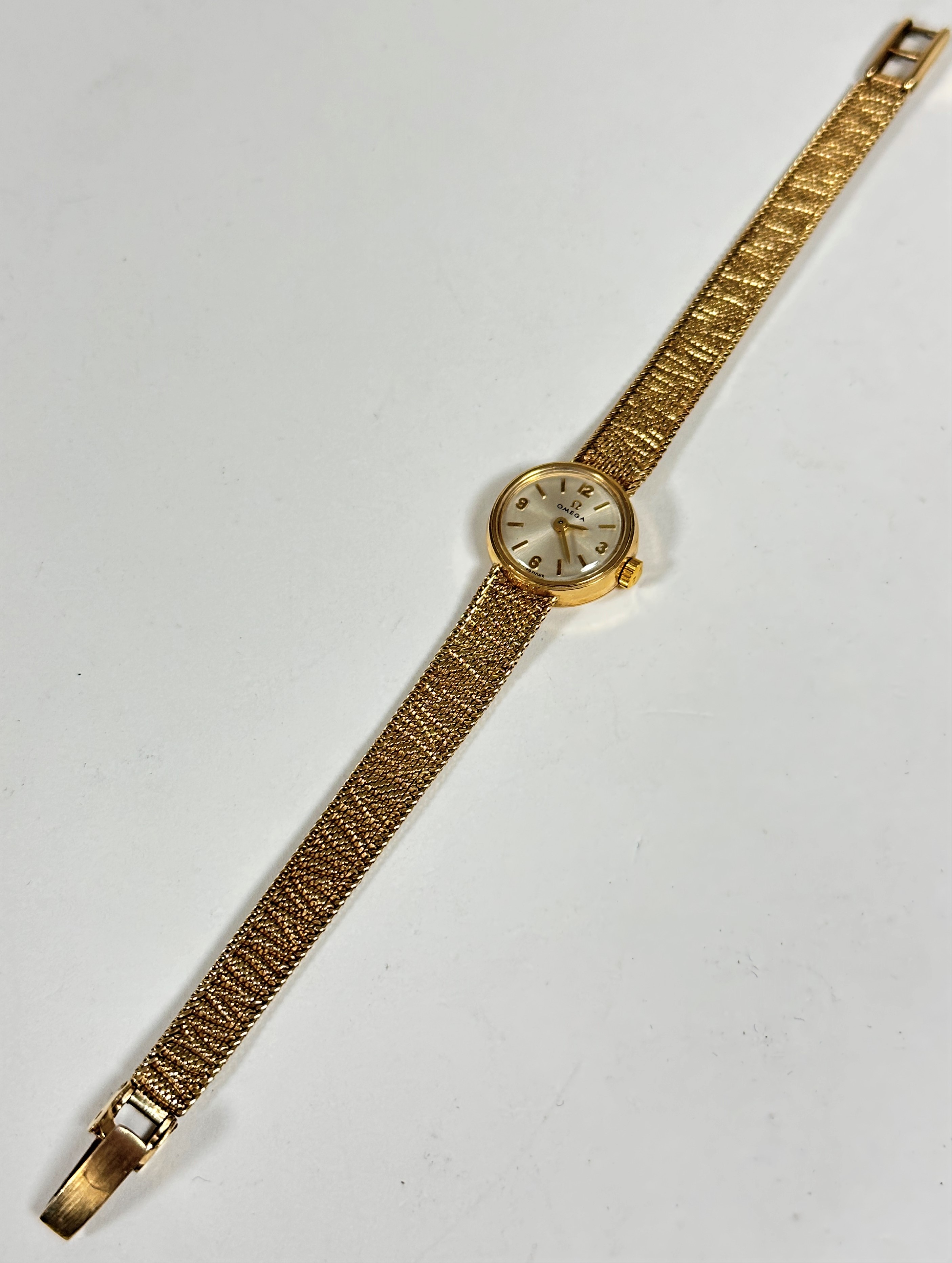 A lady's Omega 9ct gold wristwatch with silver dial and Arabic quarter hour markers and batons, (d