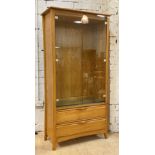 Ercol, a late 20th century blonde elm display cabinet, two glazed doors enclosing three adjustable