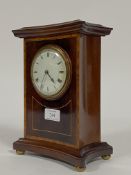 An Edwardian mantel time piece clock of concave rectangular form, the case inlaid with satinwood