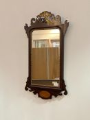 An Edwardian mahogany fretwork mirror, with ho-ho bird surmount over rectangular mirror plate within