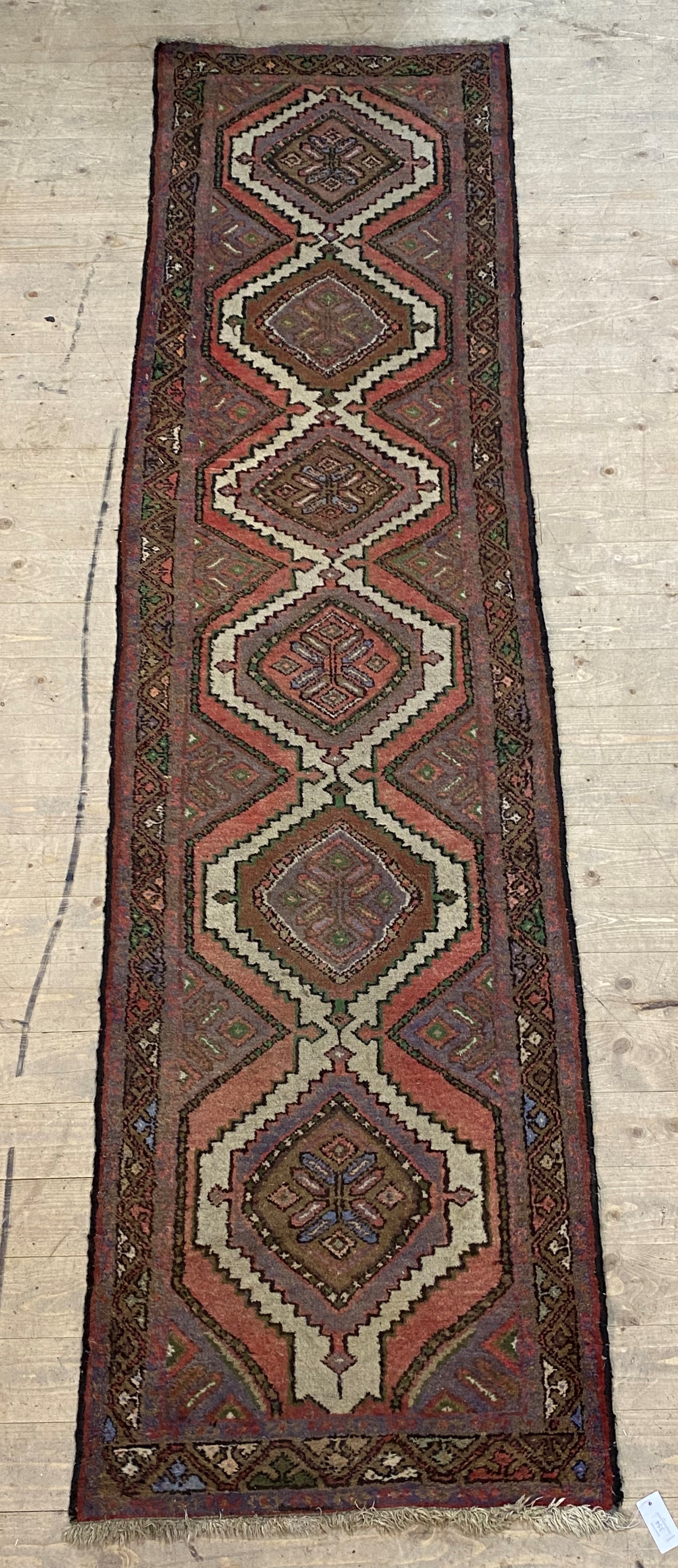 A Persian Hamadan hand knotted runner rug, with pole medallion on red field enclosed by a border - Image 2 of 2