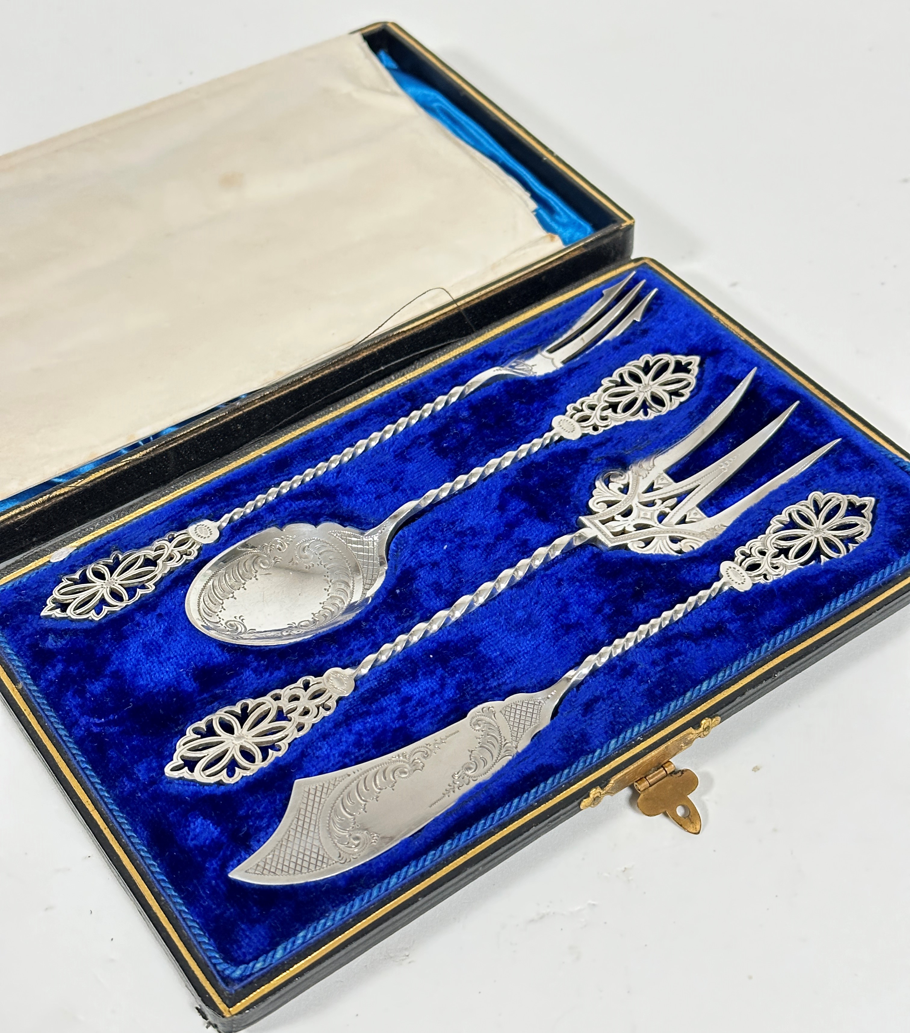 An Edwardian four piece condiment service including pickle fork, jam spoon, fish server fork and