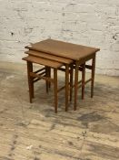 A mid century teak nest of three tables, cross banded tops raised on turned supports, H50cm,