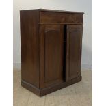 A Victorian mahogany and pine side cupboard, with frieze drawer over two panelled doors enclosing