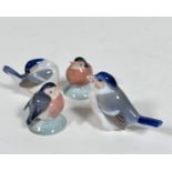 A group of four Danish Royal Copenhagen porcelain miniature bird figures including two Robins on