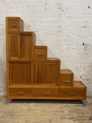 A contemporary cherry wood cabinet of stepped square form, fitted with a combination of drawers