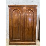 A Victorian mahogany wardrobe, the twin arched panelled doors opening to an interior fitted with