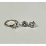 A silver paste set solitaire ring (N), a pair of silver earrings, the central diamond in illusion