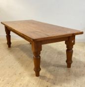 A large varnished pitch pine dining table, raised on turned supports, H78cm, L250cm, D76cm