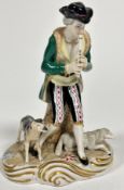 A Continental porcelain figure of a Shepherd playing a flute with seated sheep and standing