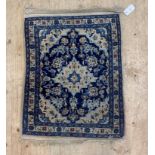 A Persian style rug, the blue field with ivory medallion and spandrels and bordered 56cm x 80cm