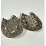 A pair of Chinese horseshoe shaped white metal belt buckles, stamped verso HC, with Chinese