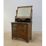 An early 20th cenrury walnut dressing chest, fitted with swing mirror over three drawers, bracket