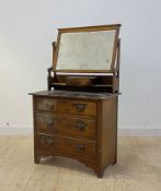 An early 20th cenrury walnut dressing chest, fitted with swing mirror over three drawers, bracket