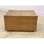 A mid century teak record cabinet, with hinged top, moving on castors, (a/f) H45cm, W82cm, D61cm