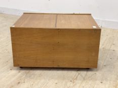 A mid century teak record cabinet, with hinged top, moving on castors, (a/f) H45cm, W82cm, D61cm