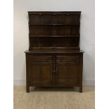 Ercol, a stained elm dresser, with three height plate rack over two drawers and twin cupboard,