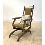 A late 19th/ early 20th century upholstered mahogany framed American rocker, on rear ceramic