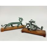 An archaic style Chinese bronzed metal elongated dragon figure, complete with hardwood stand, (h: