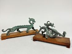 An archaic style Chinese bronzed metal elongated dragon figure, complete with hardwood stand, (h: